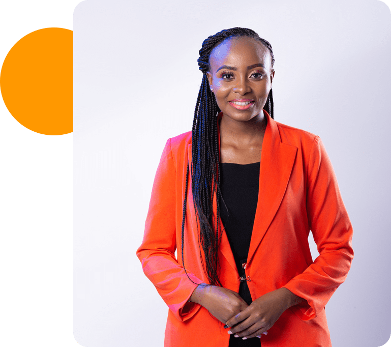 A woman in an orange jacket standing next to a green wall.