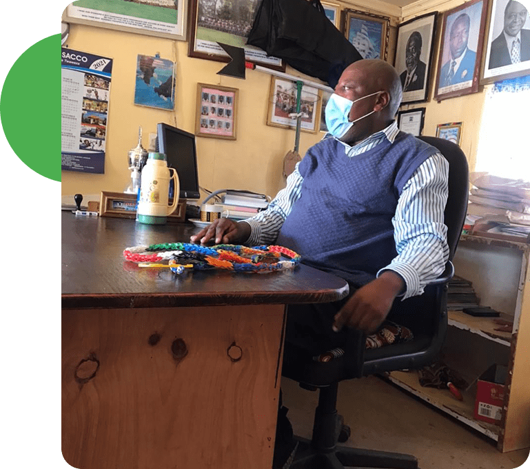 A man sitting at his desk wearing a mask.