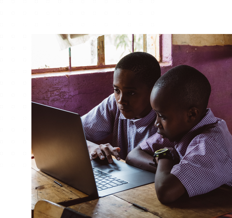 Two young boys are using a laptop computer.